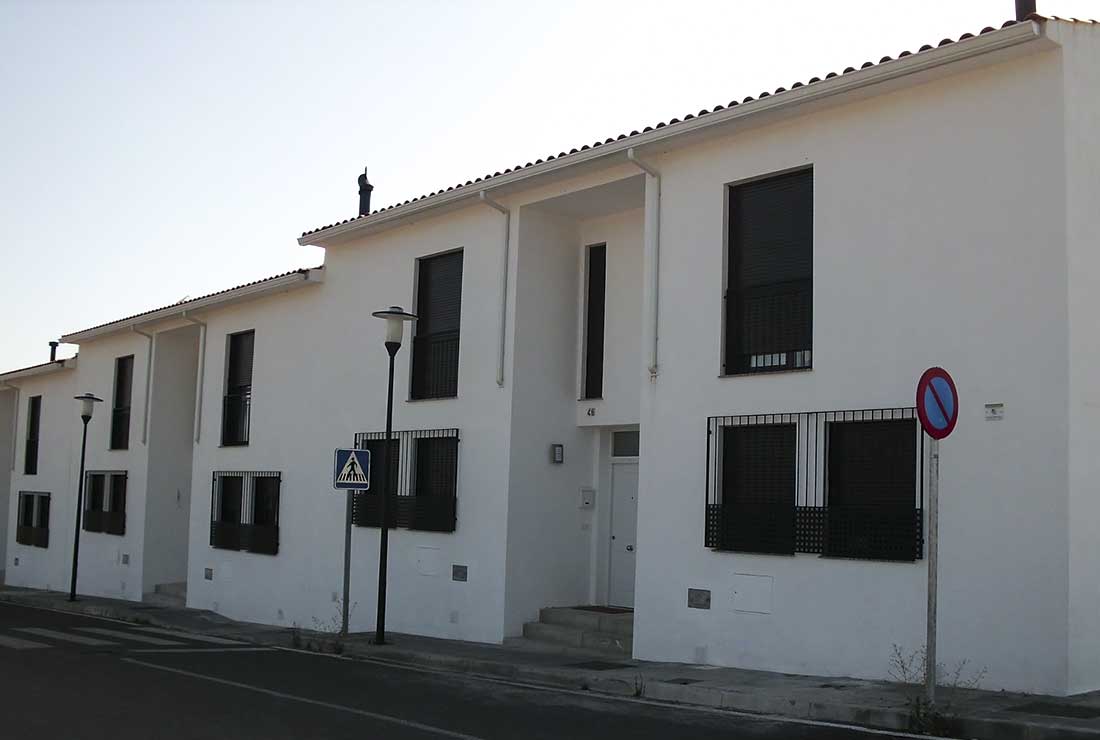 Casas blancas con contraventanas de color negro.