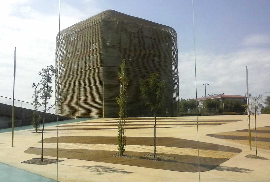 Estructura arquitectónica con forma de cubo en una plaza minimalista.